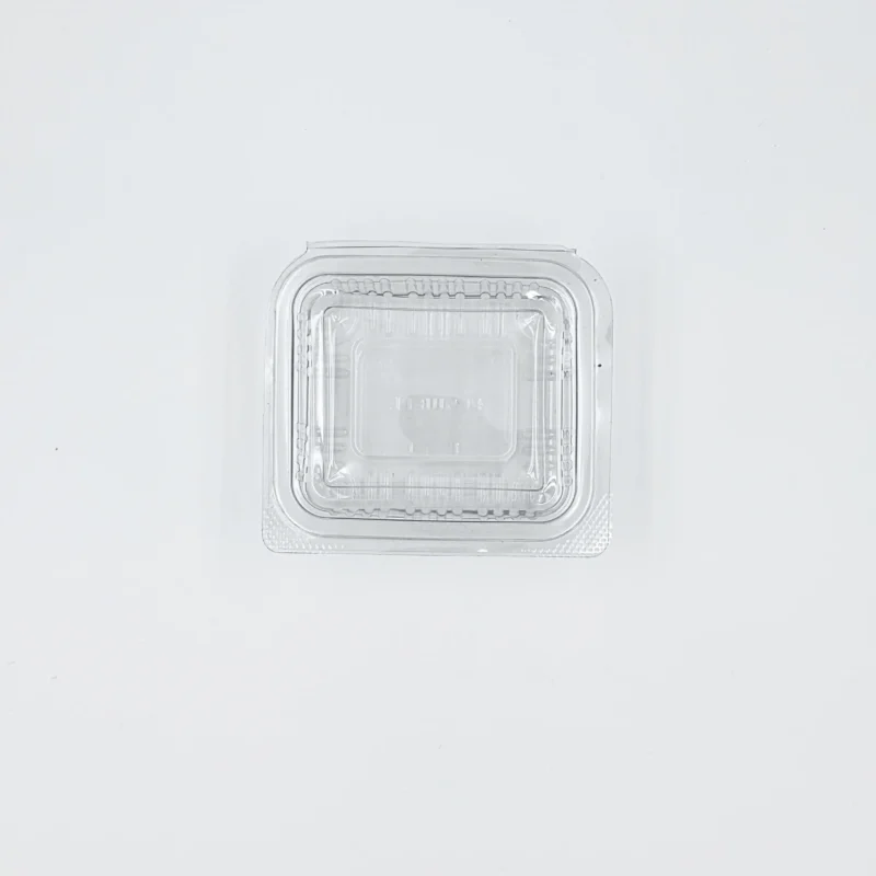 100ml 3 Top-down view of a clear plastic clamshell lid resting on a white surface, centered toward the bottom of the image.