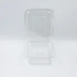 Close-up of a transparent plastic blister pack on a white surface, showing rounded corners and a perforated edge corner.