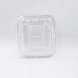 Close-up of a clear plastic blister packaging with rounded corners and a textured inner surface, photographed from above-left edge.