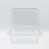 Clear plastic takeout container with a snap-on lid on a white surface.