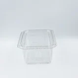 Clear plastic takeout container lid on a light background, viewed from above.
